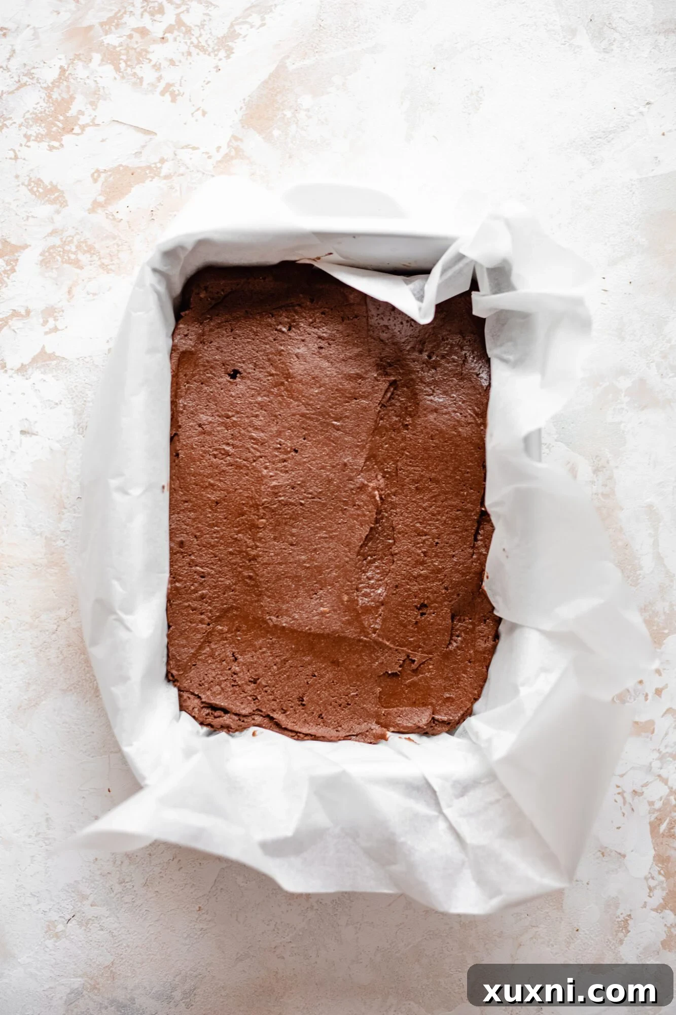 thick sweet potato brownie batter poured into a baking pan