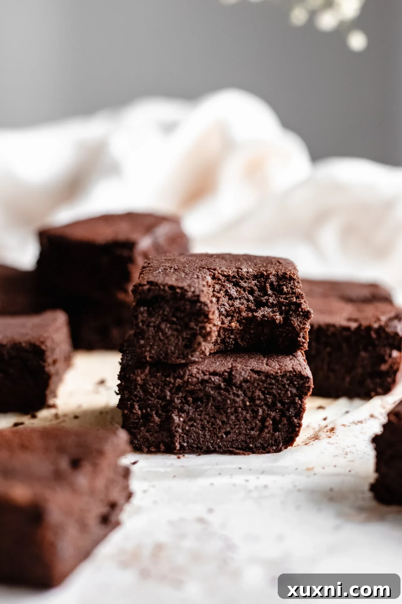 a towering stack of vegan brownies, showcasing their irresistible texture