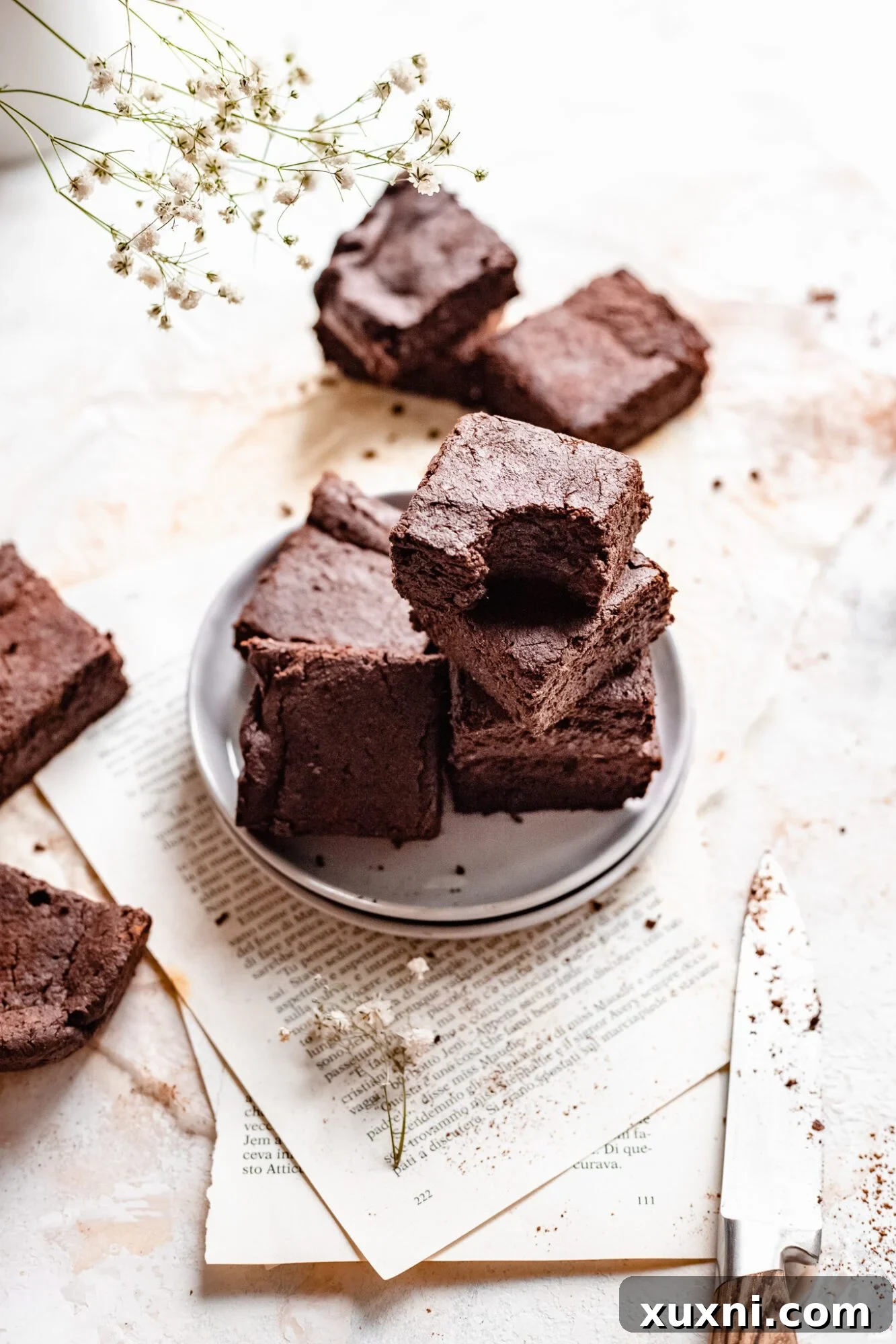 a stack of vegan brownies placed on the open pages of a book, creating a cozy aesthetic