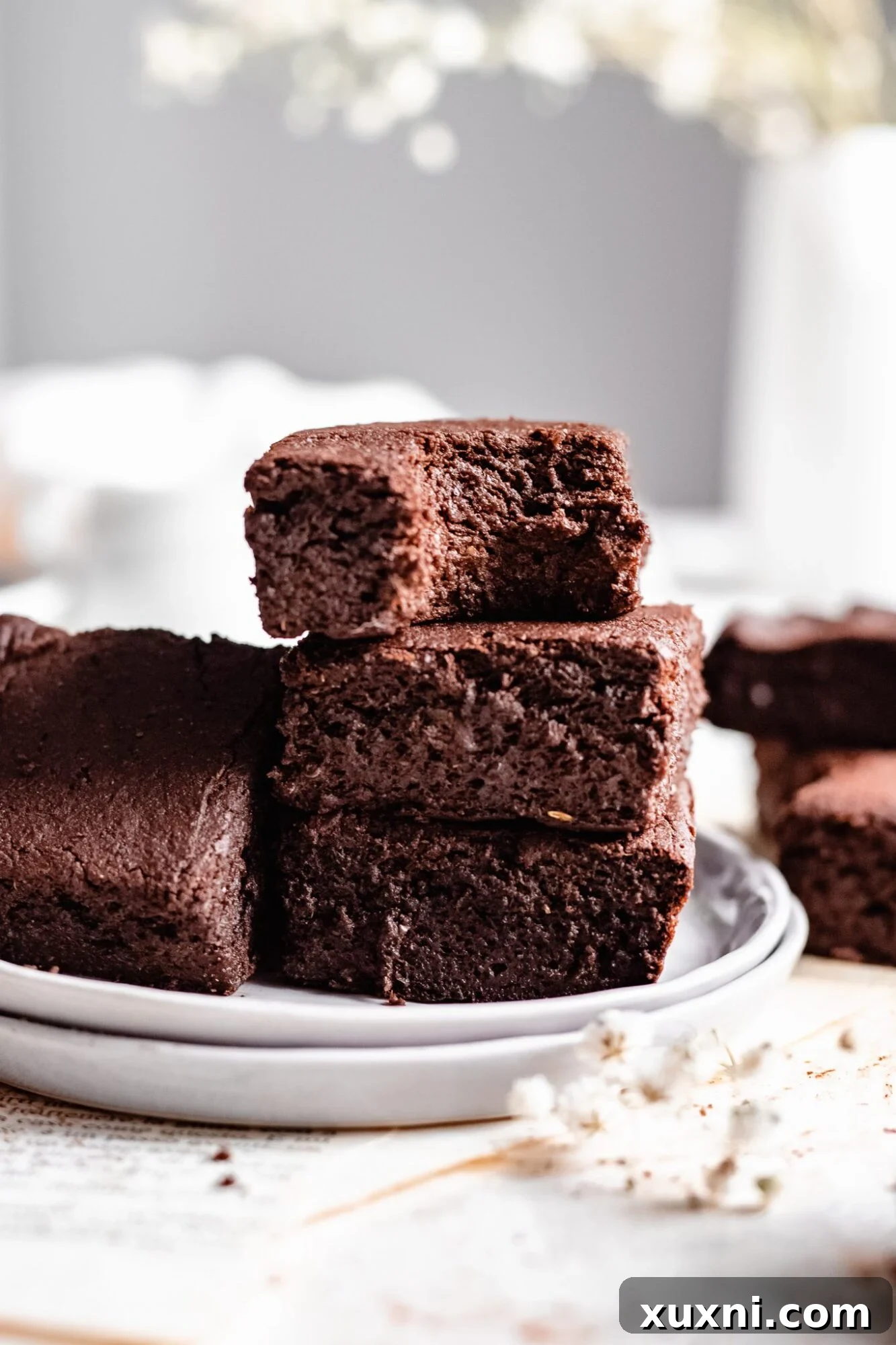 another view of stacked brownies with a bite taken out, revealing the rich interior