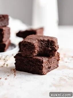 stacked brownies with bite taken out, enticing viewers with its texture