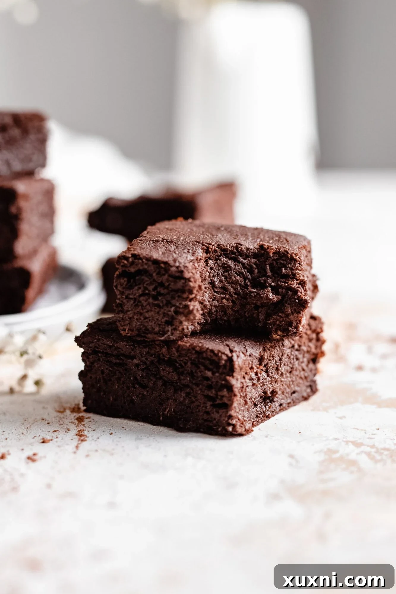 stacked brownies with one having a bite taken out, revealing its soft interior