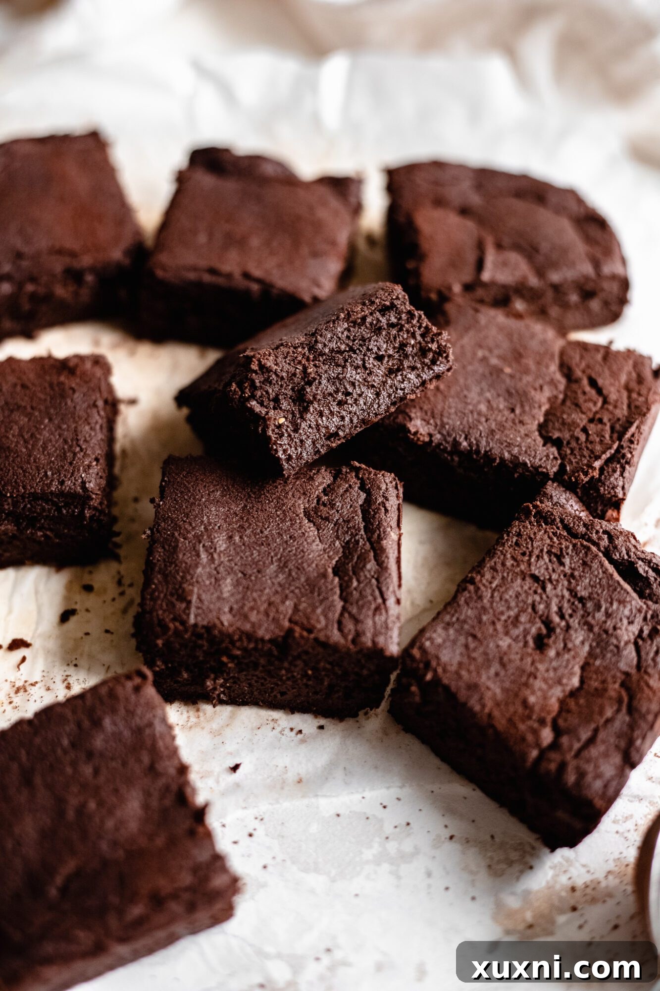 a generous scattering of freshly baked brownies on a sheet of parchment paper