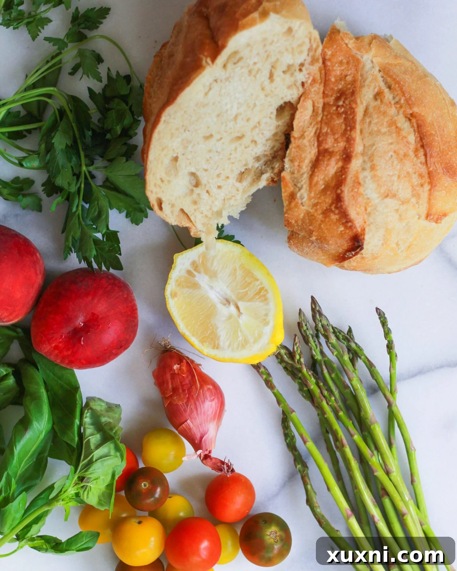 loaf of bread with peaches, asparagus, shallots, heirloom tomatoes, basil, and parsley