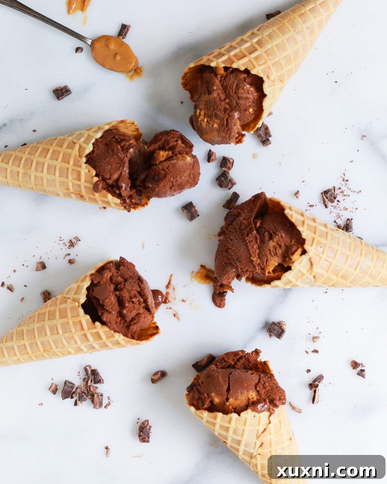 ice cream cones filled with dairy free chocolate peanut butter nice cream on marble slab