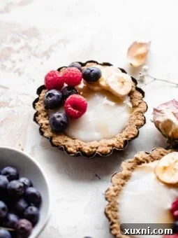 A single mini fruit tart, elegantly plated, highlighting its fresh components and inviting appeal.