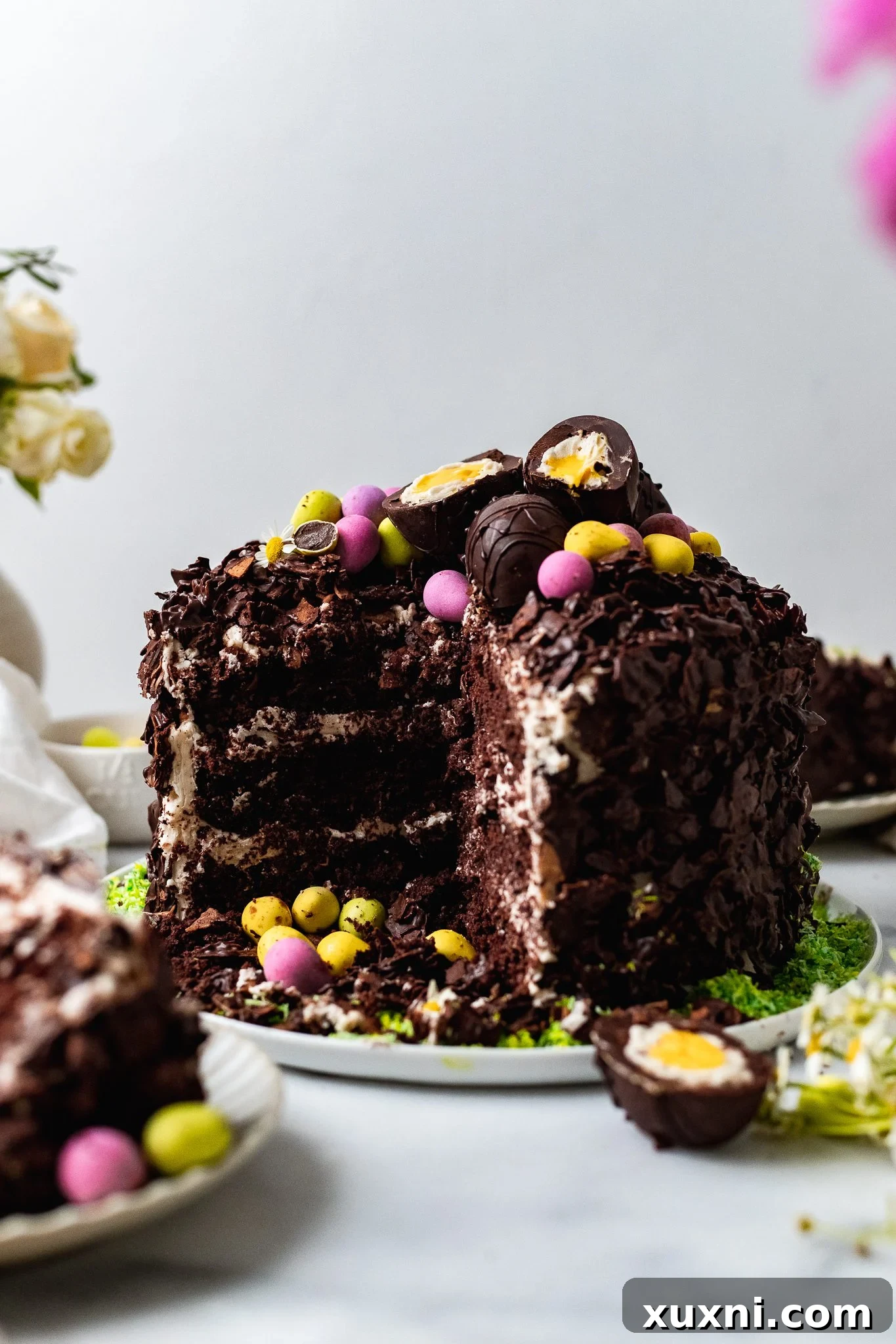 A perfectly sliced chocolate Easter egg cake on a serving plate, showcasing its layers and festive decoration.