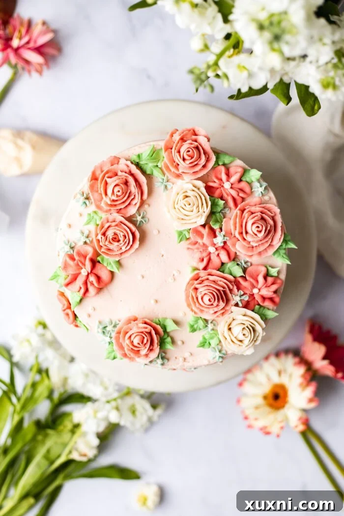 Easy Buttercream Blooms Cake 2 Exquisite buttercream flower cake adorned with various flowers on a marble surface, ready for celebration