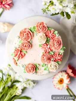 buttercream flower cake with flowers around it on marble