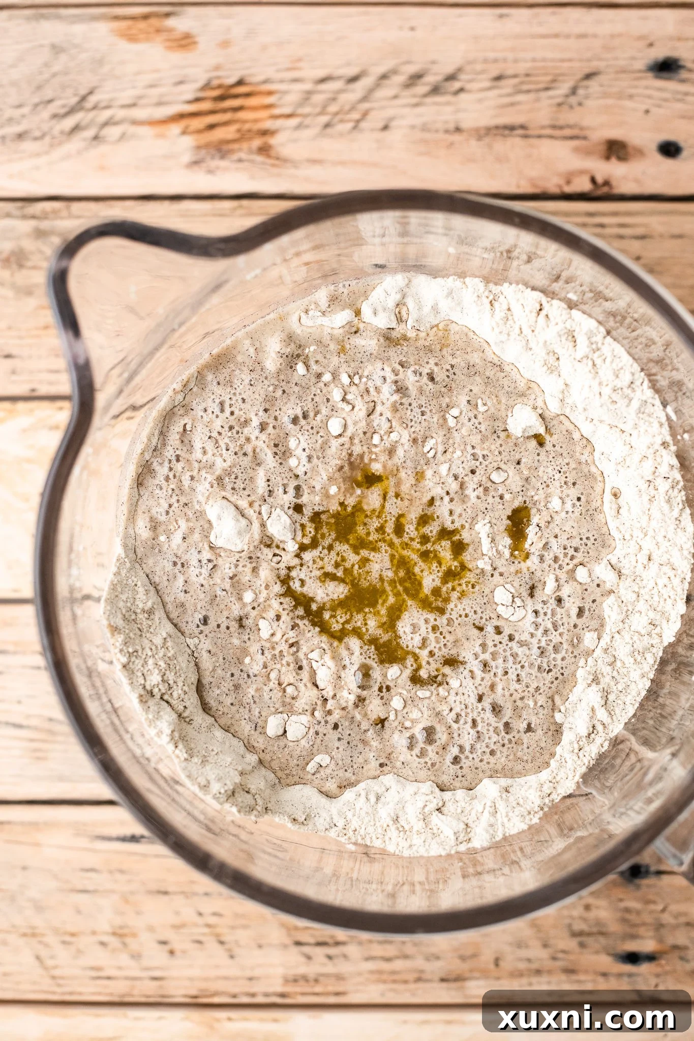 Your Perfect Gluten-Free Sandwich Bread: Homemade, Egg & Dairy-Free 6 Wet ingredients being poured into a stand mixer bowl containing dry ingredients, ready to be mixed into gluten-free dough.