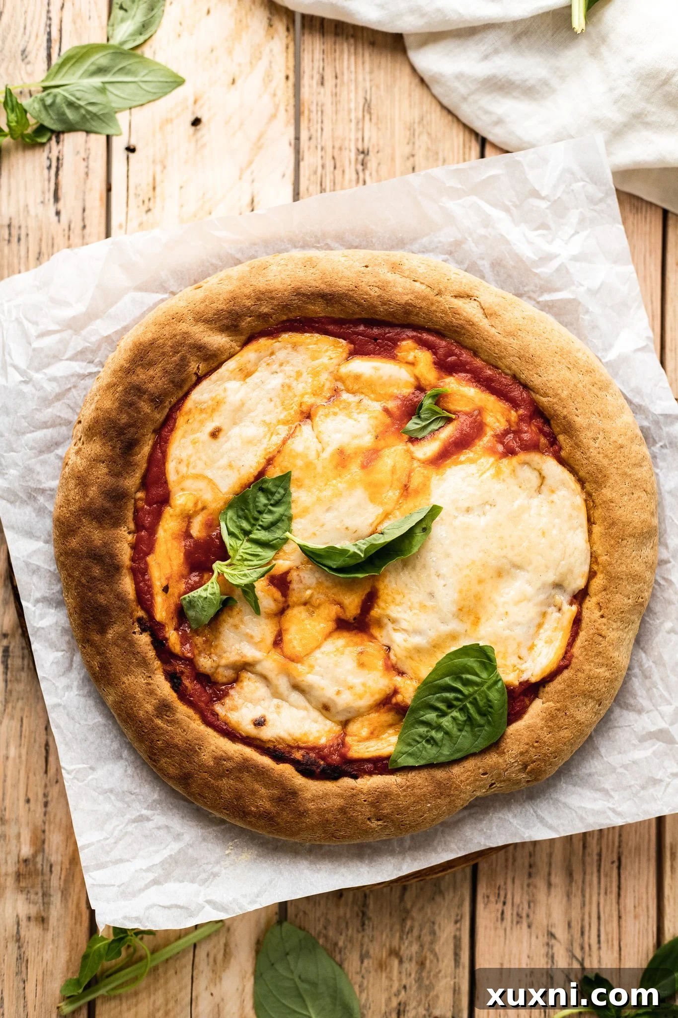 Fully baked gluten free pizza with melted vegan cheese