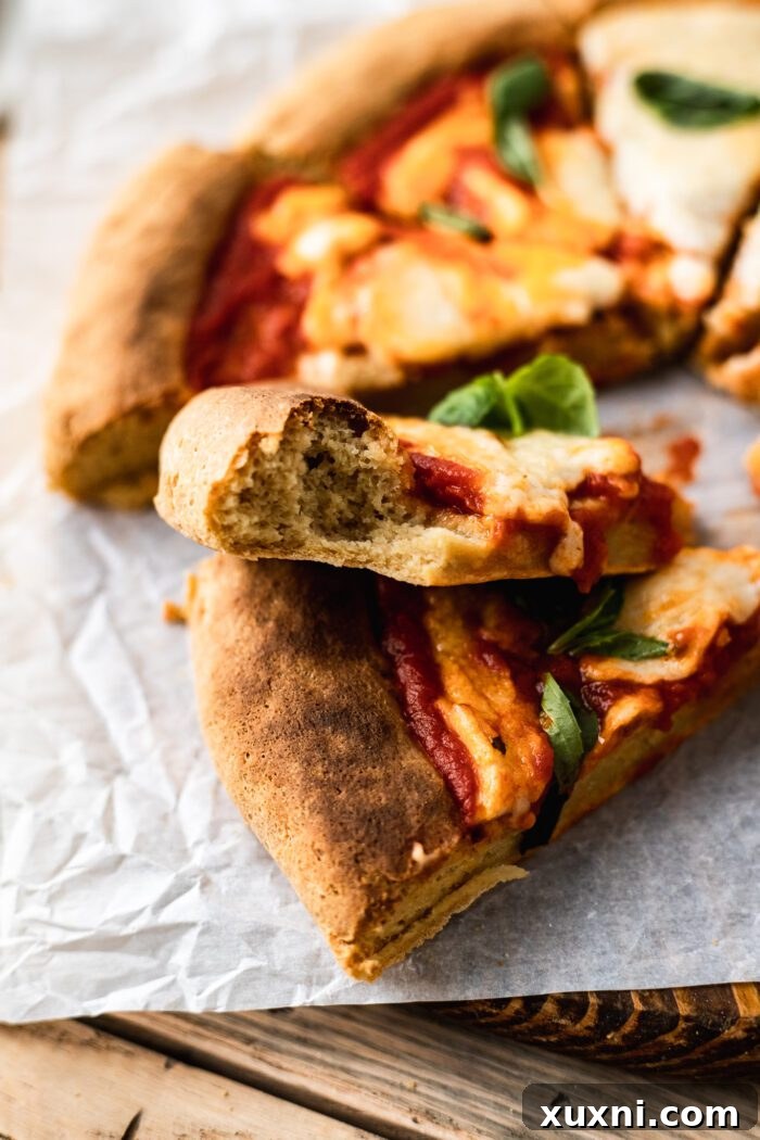 A slice of gluten free pizza with a bite taken out