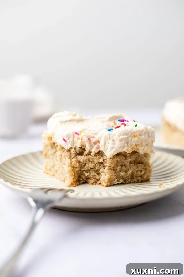 Easy & Delicious Vegan Vanilla Sheet Cake 9 a bite taken from a slice of vanilla sheet cake, showing its soft texture