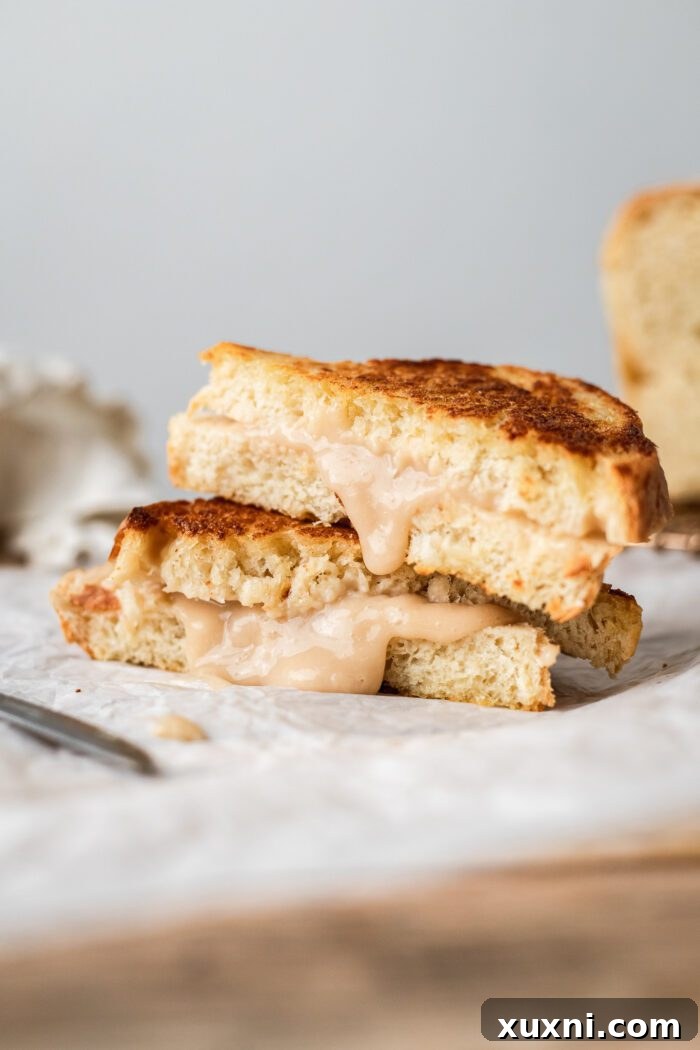 Gooey vegan grilled cheese sandwich made with homemade bean-based mozzarella, served on parchment paper