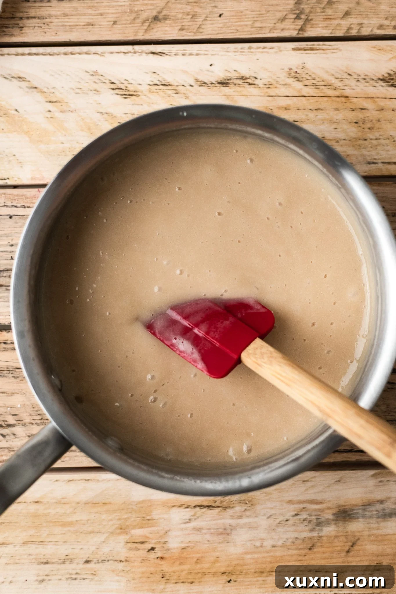 Cooking the bean-based vegan mozzarella in a small saucepan, stirring continuously to thicken