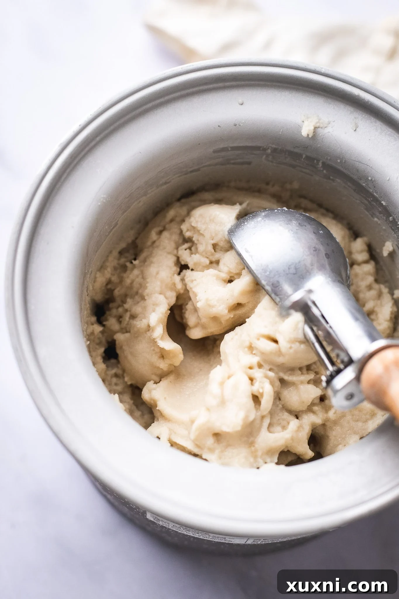 Churned vegan vanilla ice cream in an ice cream maker bowl