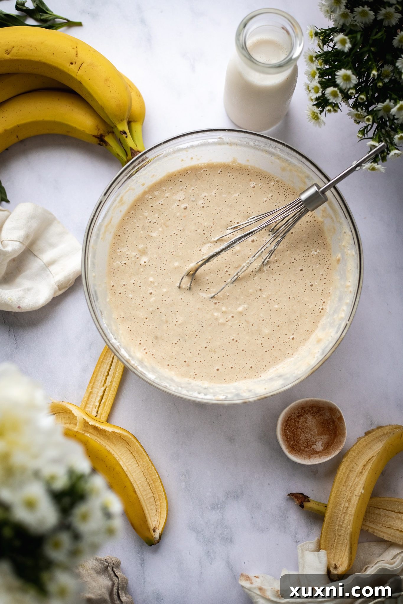 banana pancake batter being mixed in a bowl, showing a slightly lumpy consistency