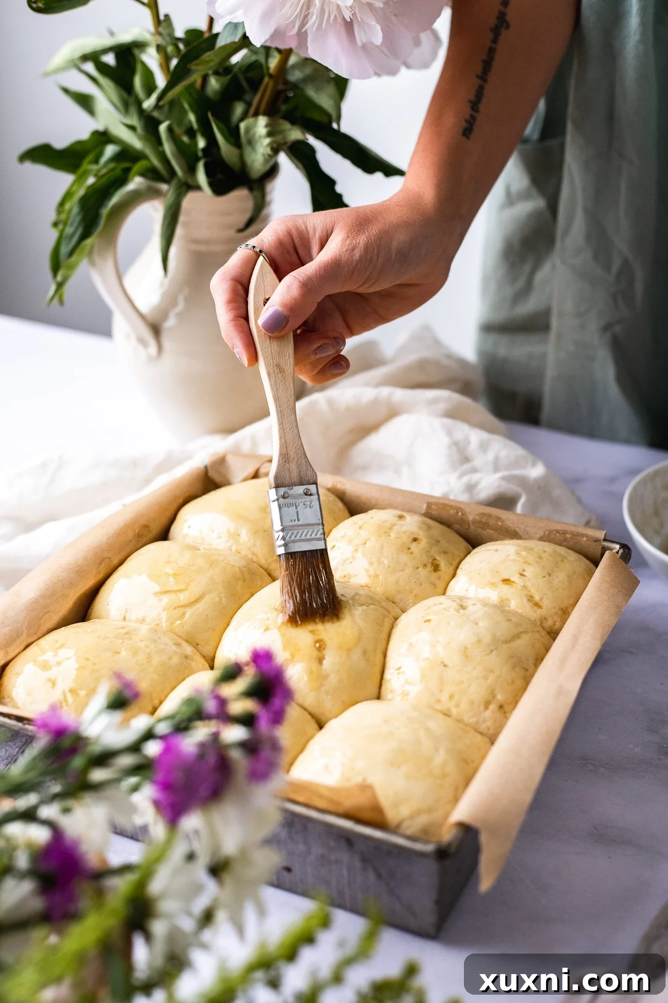 Pillowy Soft Gluten-Free Vegan Dinner Rolls, Made Easy 10 gluten free dinner rolls being brushed with vegan egg wash