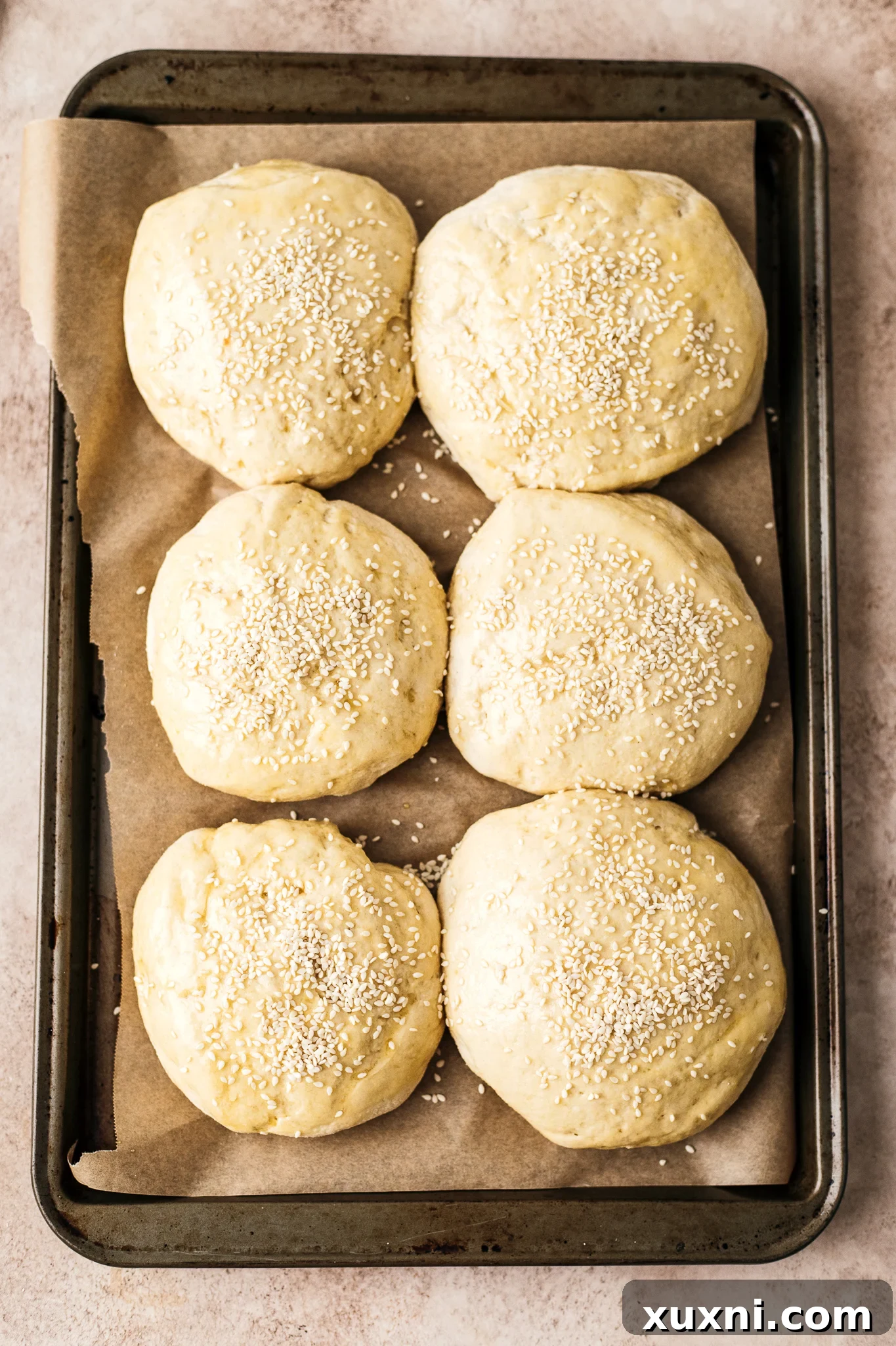 gluten free burger buns brushed with vegan egg wash and sesame seeds