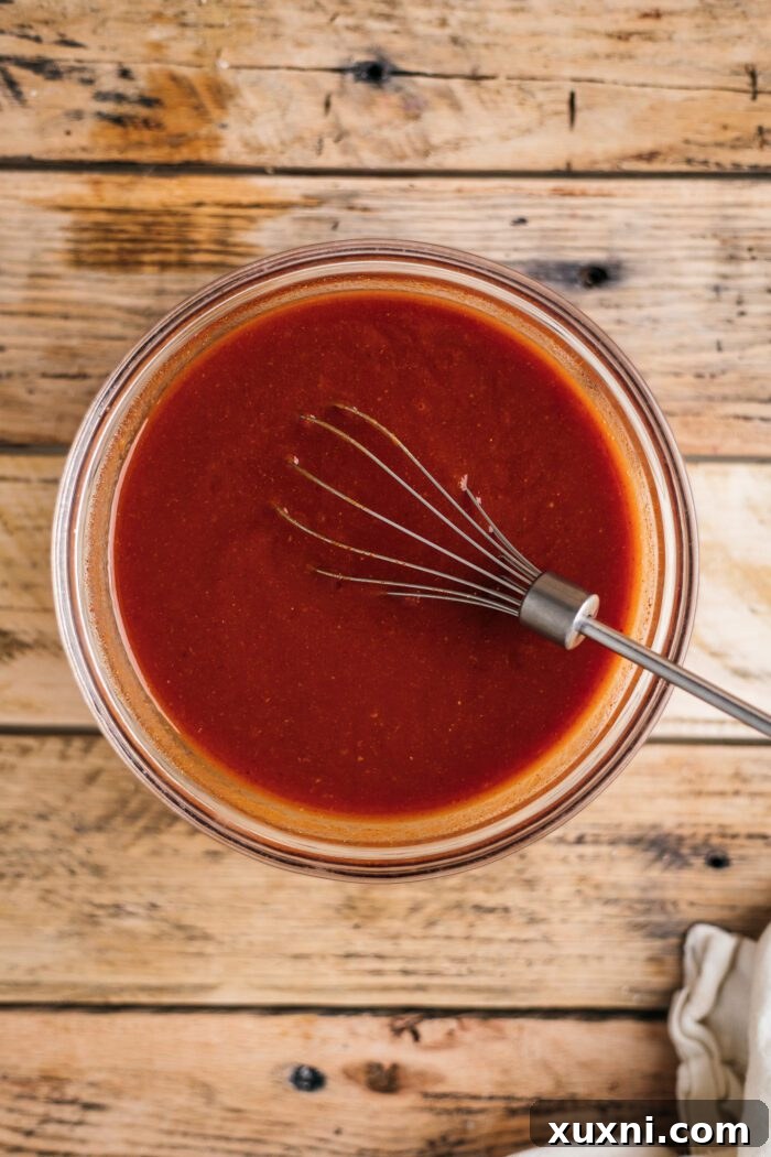 mixing barbecue sauce in a bowl with a whisk