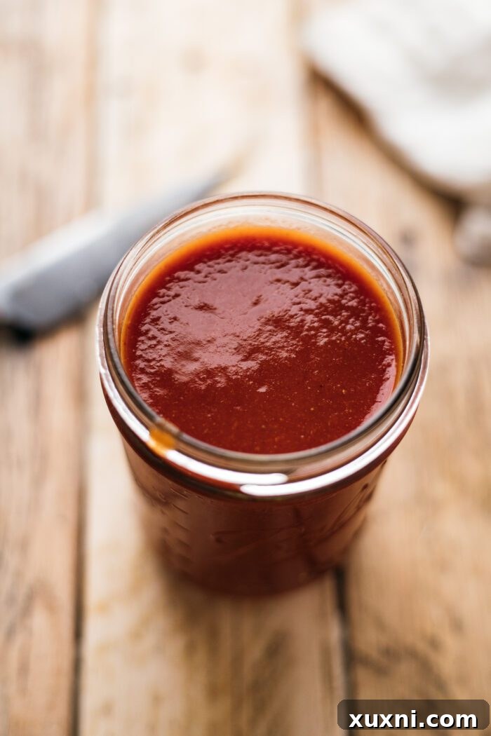 vegan barbecue sauce in a glass jar with a spoon