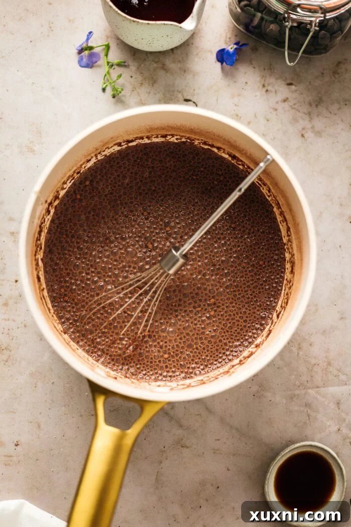 Quick and Easy Vegan Chocolate Pudding Dream 5 Whisking dairy-free milk, maple syrup, cocoa powder, and arrowroot starch in a saucepan.