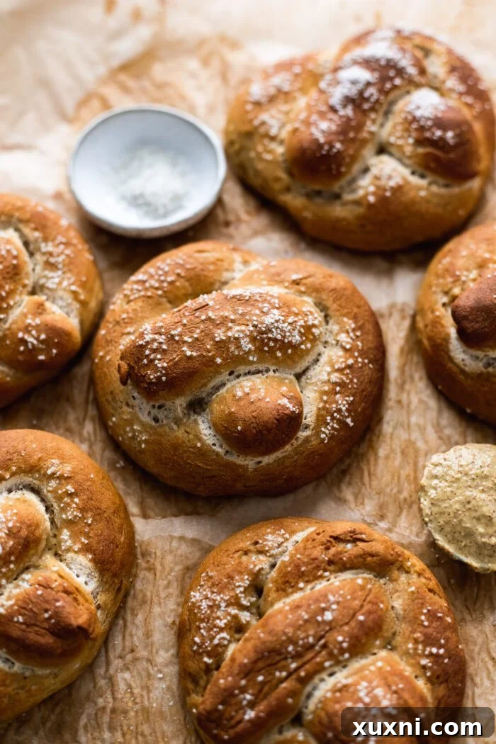 Pillowy Soft Gluten Free Vegan Pretzels 2 gluten free soft pretzels on parchment paper