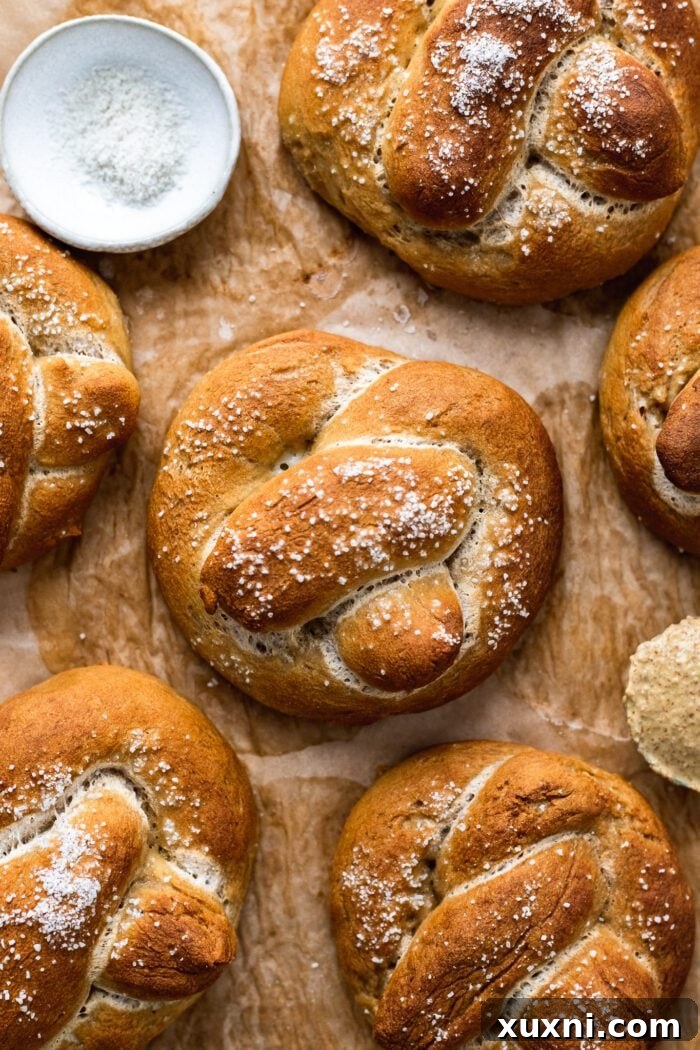 Pillowy Soft Gluten Free Vegan Pretzels 3 gluten free soft pretzels on parchment paper