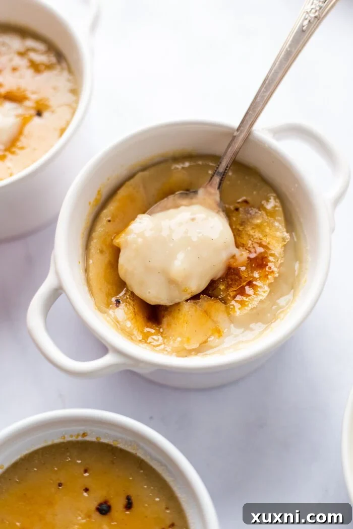 A hand gently serving a vegan crème brûlée, showcasing its readiness to be enjoyed.