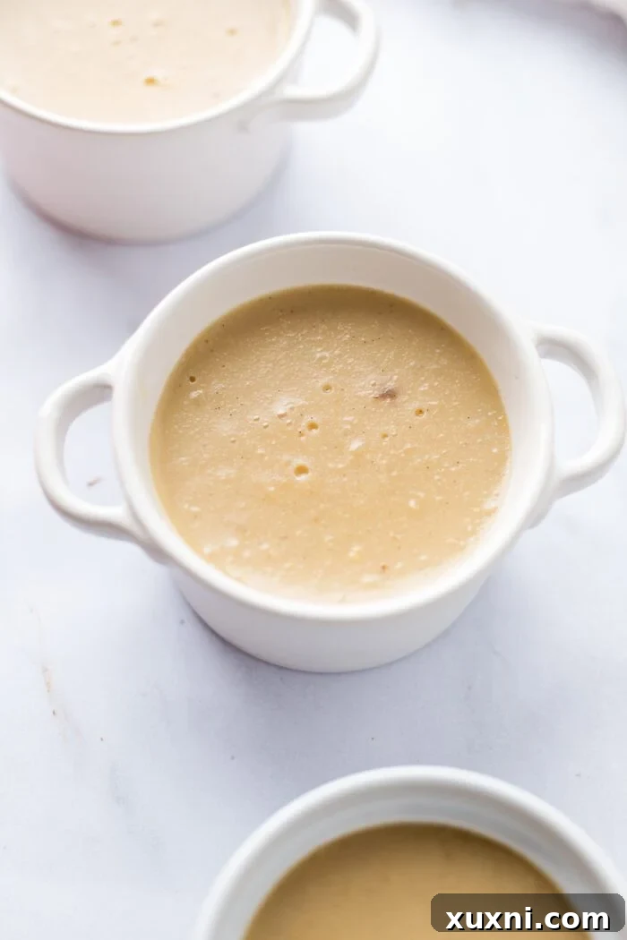 Several ramekins of vegan crème brûlée, fully set and chilled, ready for the caramelizing step.