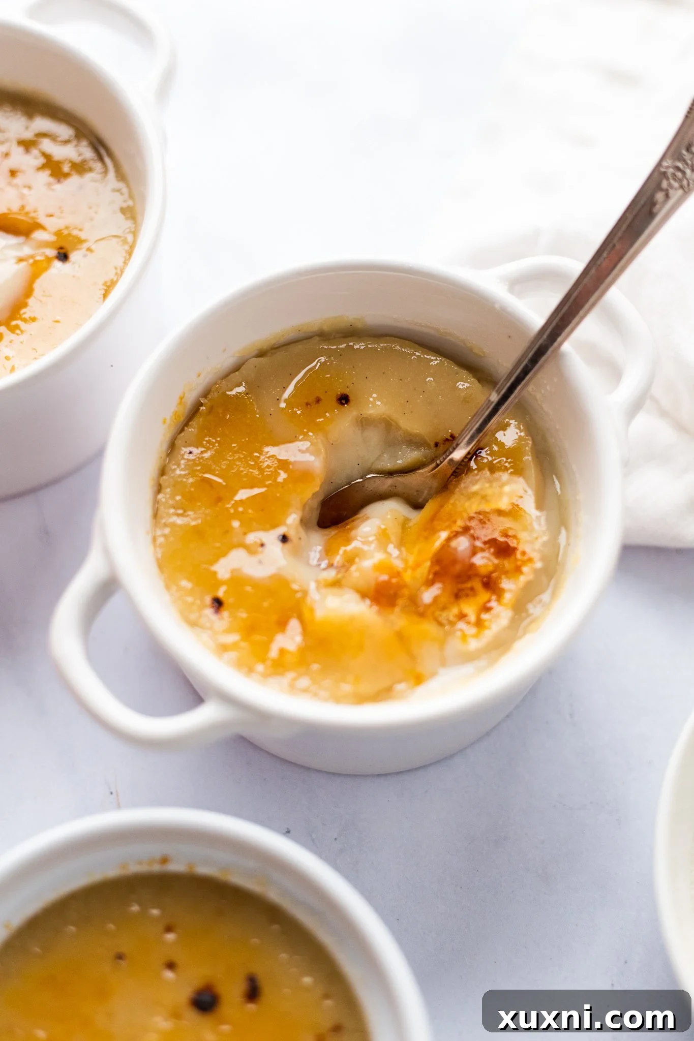 Another perspective of a vegan crème brûlée in a ramekin, highlighting its rich color and texture.