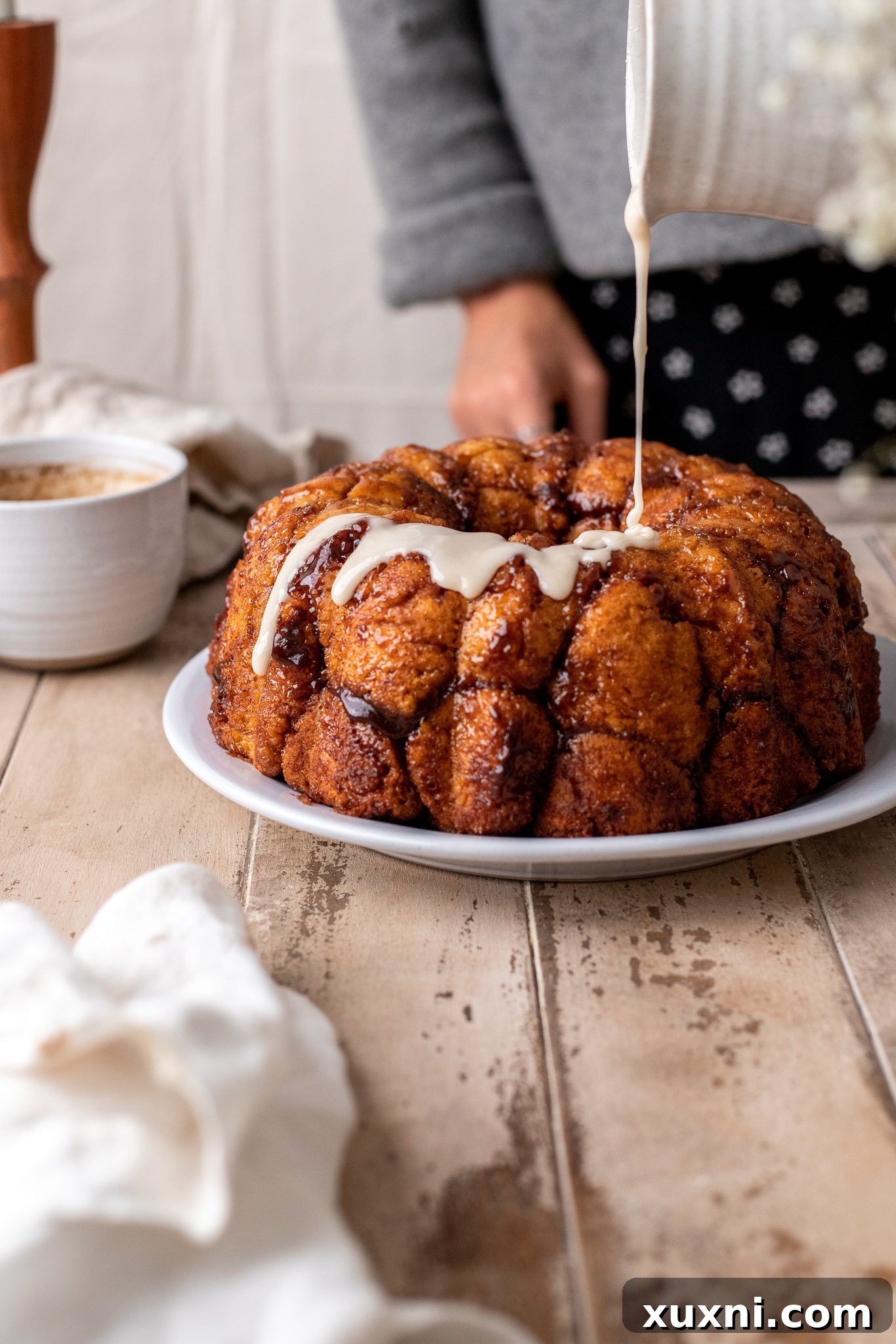 The Classic Soft and Fluffy Gluten-Free Monkey Bread 12 A cascade of sweet white glaze being poured generously over warm, baked vegan monkey bread.