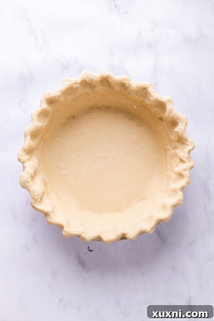 Unbaked gluten-free pie crust in a pie dish, ready for chilling.