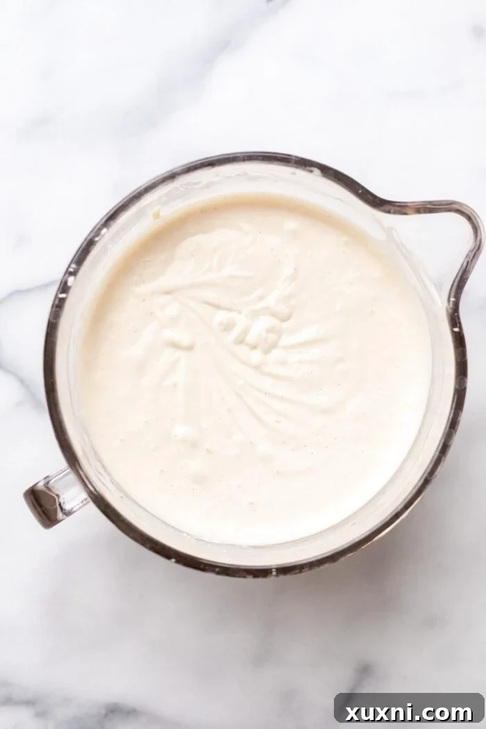 Luxurious Plant-Based Gluten-Free Cannoli Cheesecake 6 Image showing the creamy vegan cannoli cheesecake filling being mixed in a stand mixer, demonstrating its smooth and airy consistency.