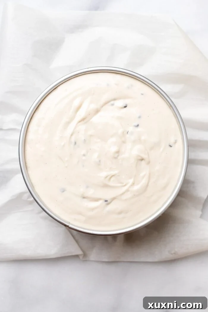 Luxurious Plant-Based Gluten-Free Cannoli Cheesecake 8 The unbaked cannoli cheesecake batter, studded with chocolate chips, poured into the pre-baked oat crust in a springform pan.