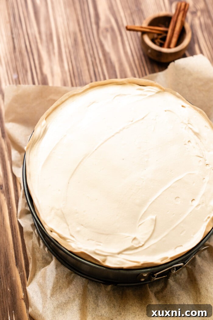 Ultimate Gooey Vegan Pecan Pie Cheesecake 12 Smooth vegan cheesecake batter being poured over the pecan pie filling in the crust.