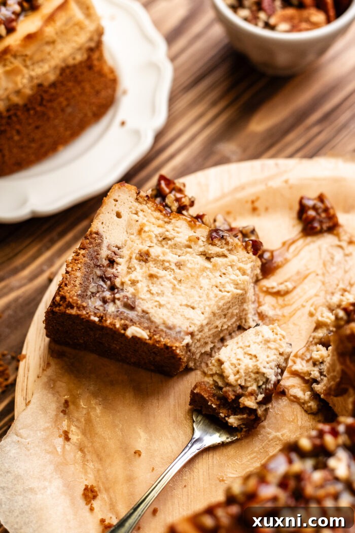 Ultimate Gooey Vegan Pecan Pie Cheesecake 16 A slice of vegan pecan pie cheesecake with a bite taken out, showing its creamy texture and pecan layers.