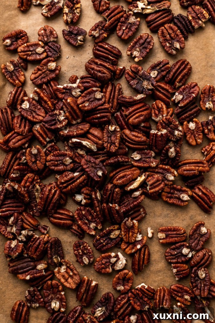 Ultimate Gooey Vegan Pecan Pie Cheesecake 5 Freshly toasted pecans arranged on a baking sheet, ready for incorporation into the cheesecake layers.