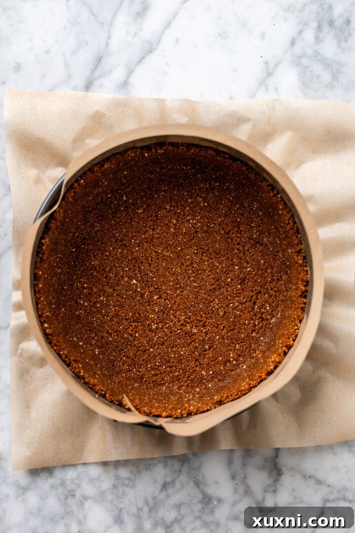 Ultimate Gooey Vegan Pecan Pie Cheesecake 6 A freshly pressed ginger pecan crust in a springform pan, pre-baking.