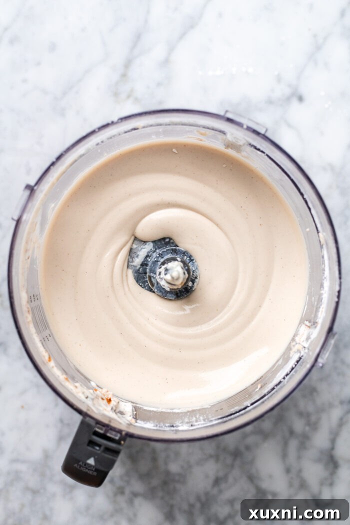 Ultimate Gooey Vegan Pecan Pie Cheesecake 7 Smooth and creamy vegan cheesecake batter in a food processor, ready to be poured.