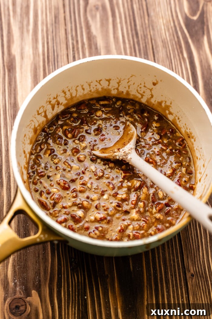 Ultimate Gooey Vegan Pecan Pie Cheesecake 9 Gooey pecan pie filling simmering in a saucepan.