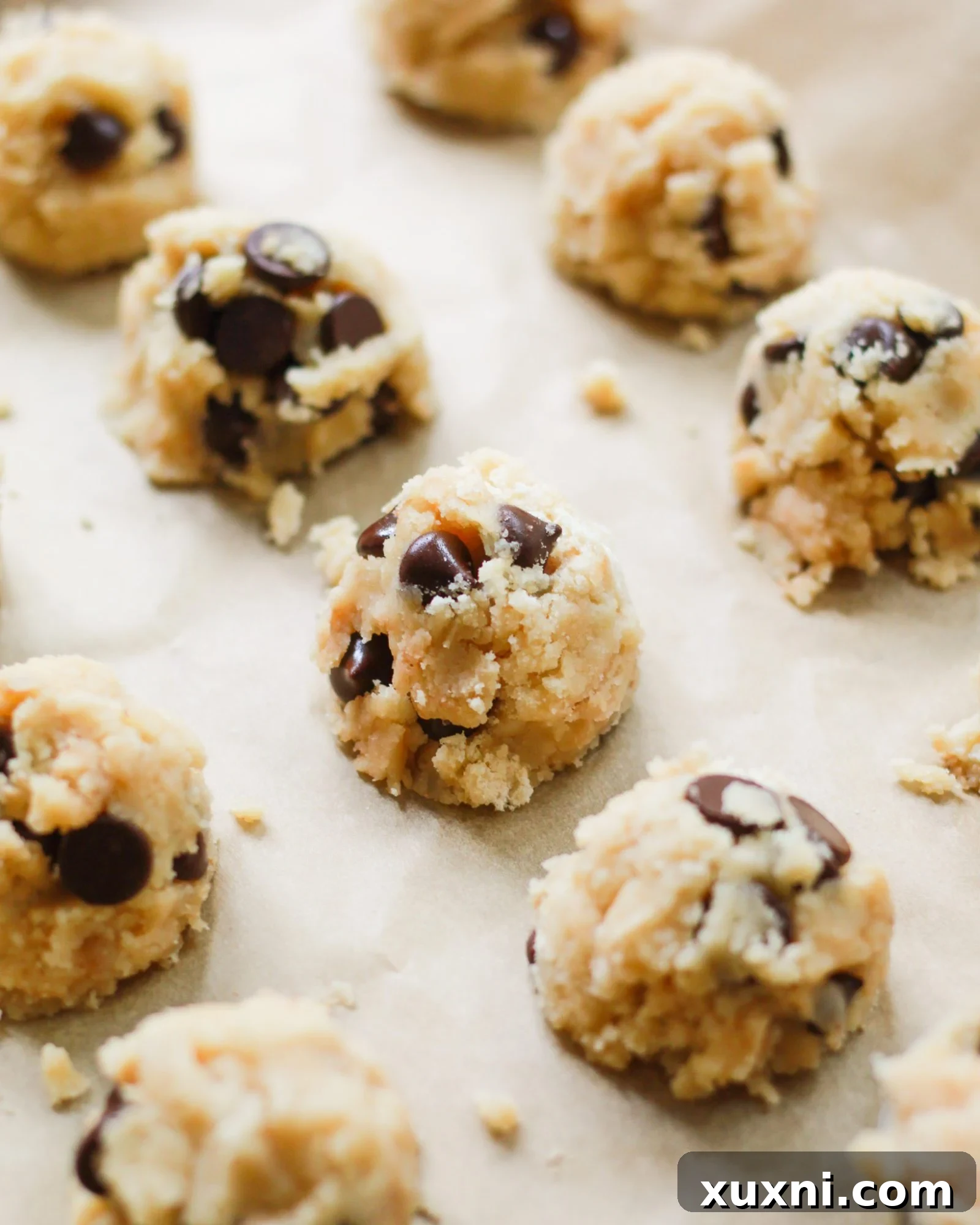 cookie dough truffles scooped onto parchment paper