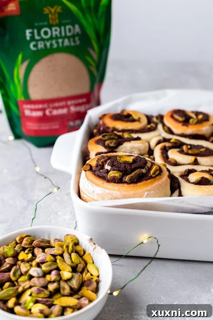 A baking dish filled with freshly baked Vegan Chocolate Pistachio Sweet Rolls, still warm from the oven.