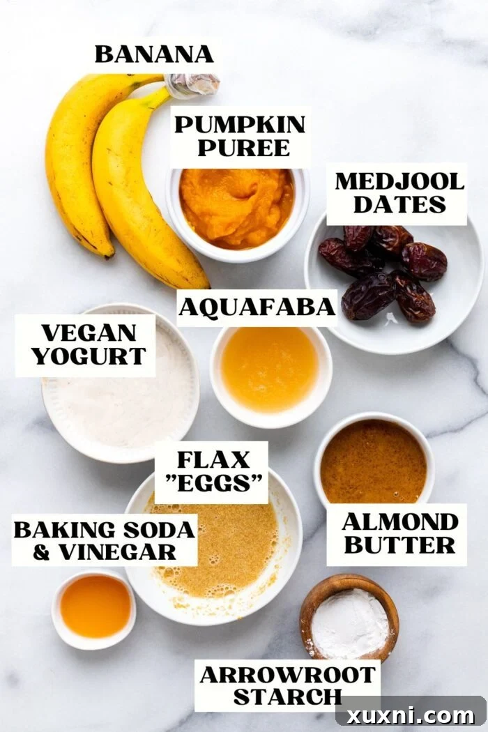 Various vegan egg substitutes displayed on a marble surface, including applesauce, flax seeds, aquafaba, and plant-based yogurt cups.