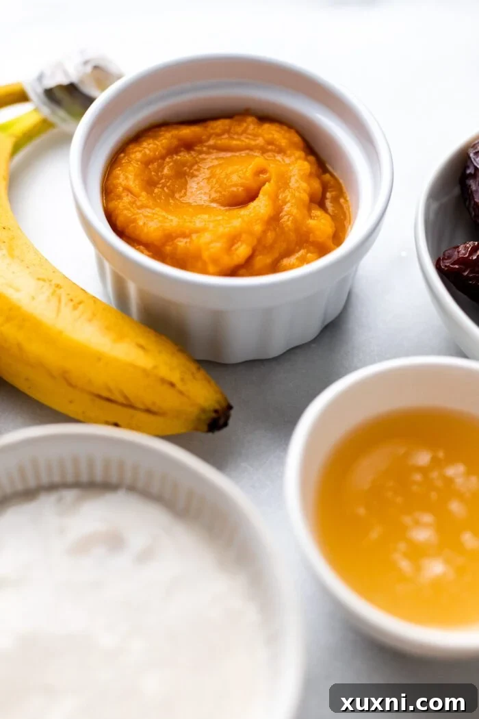 A close-up view of various vegan egg replacements in small bowls, including a flax egg, applesauce, pumpkin puree, and dairy-free yogurt, arranged on a marble background.