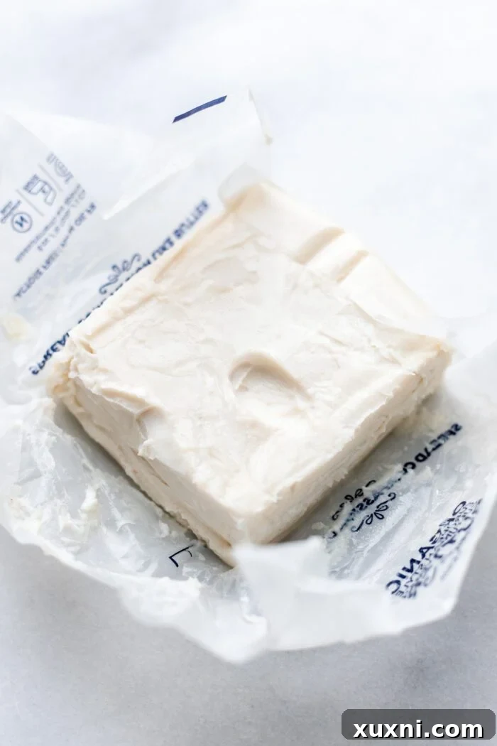 Perfectly softened room temperature butter with a subtle fingerprint indentation, ready for baking.