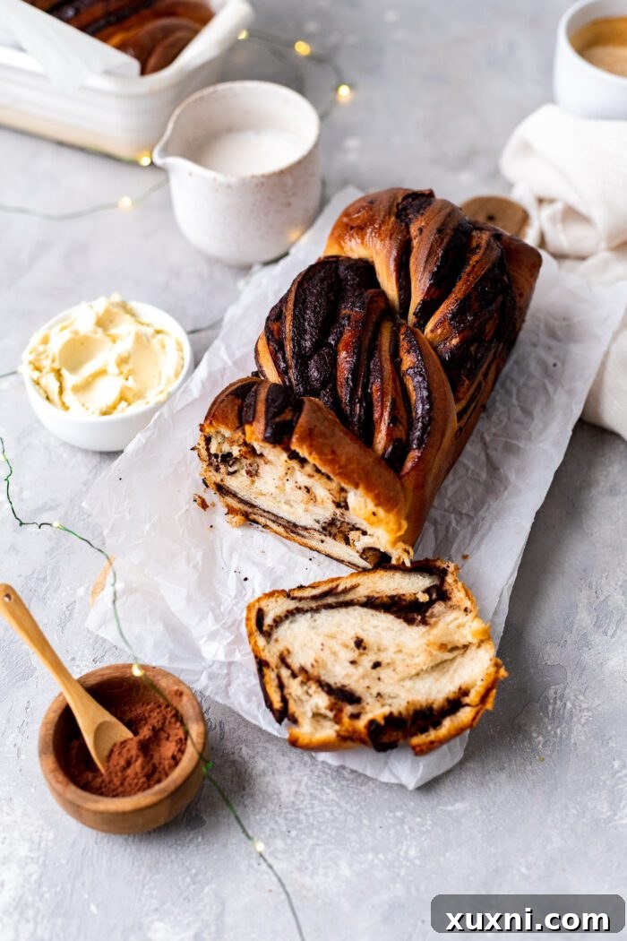 A freshly baked loaf of vegan chocolate babka on a wooden cutting board