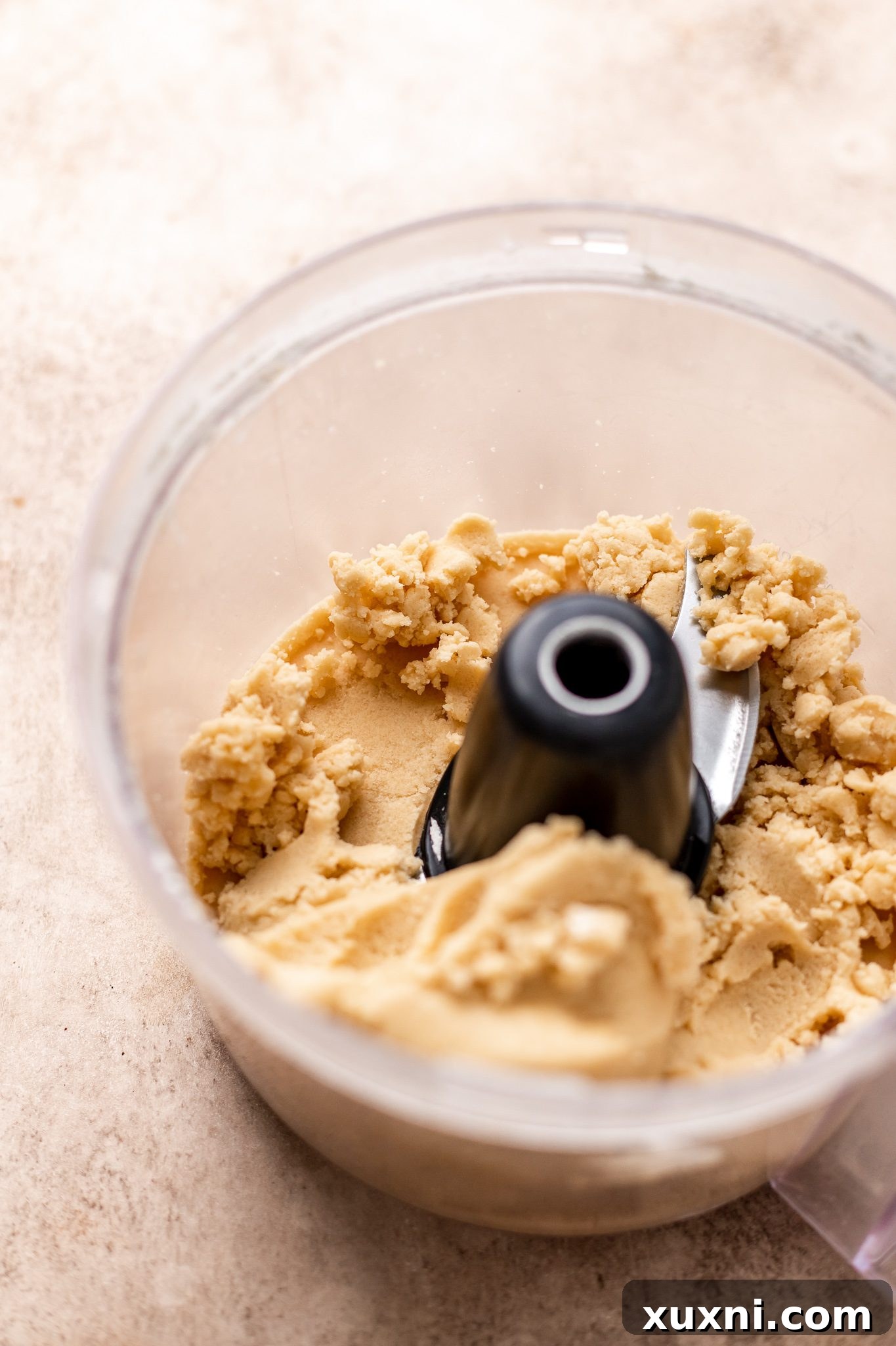 Close-up of peppermint meltaway cookie dough inside a food processor, perfectly mixed and ready.