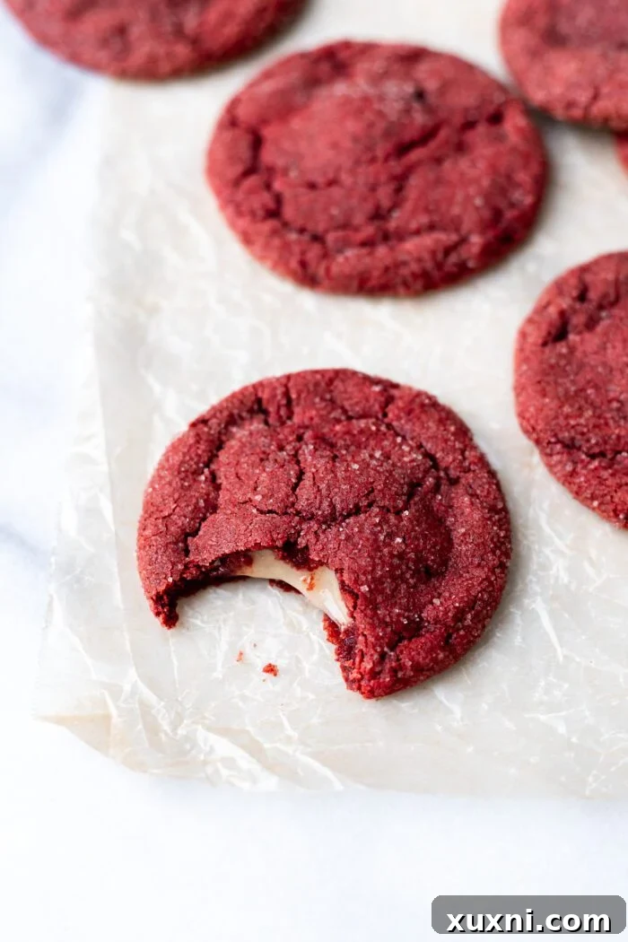 vegan red velvet cookies with cream cheese filling and bite taken out of it