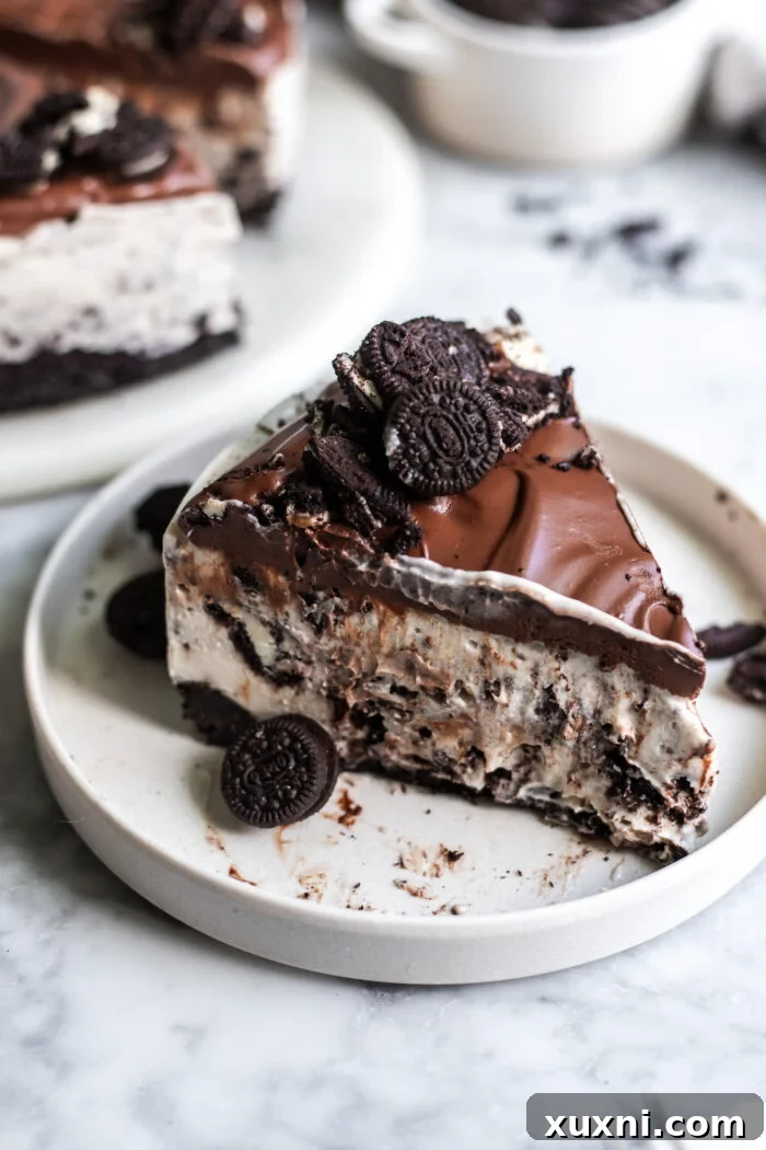 A perfectly sliced no-bake vegan Oreo cheesecake on a white plate, showcasing its creamy layers and cookie crust, ready to be enjoyed.